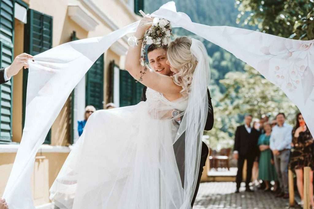 Bräutigam trägt Braut nach der Trauung